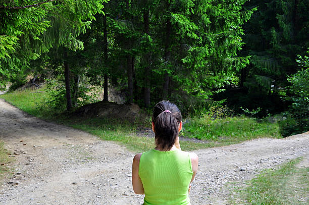 Frau vor Weggabelung im Wald – Symbolbild für Beziehungsentscheidung bleiben oder gehen